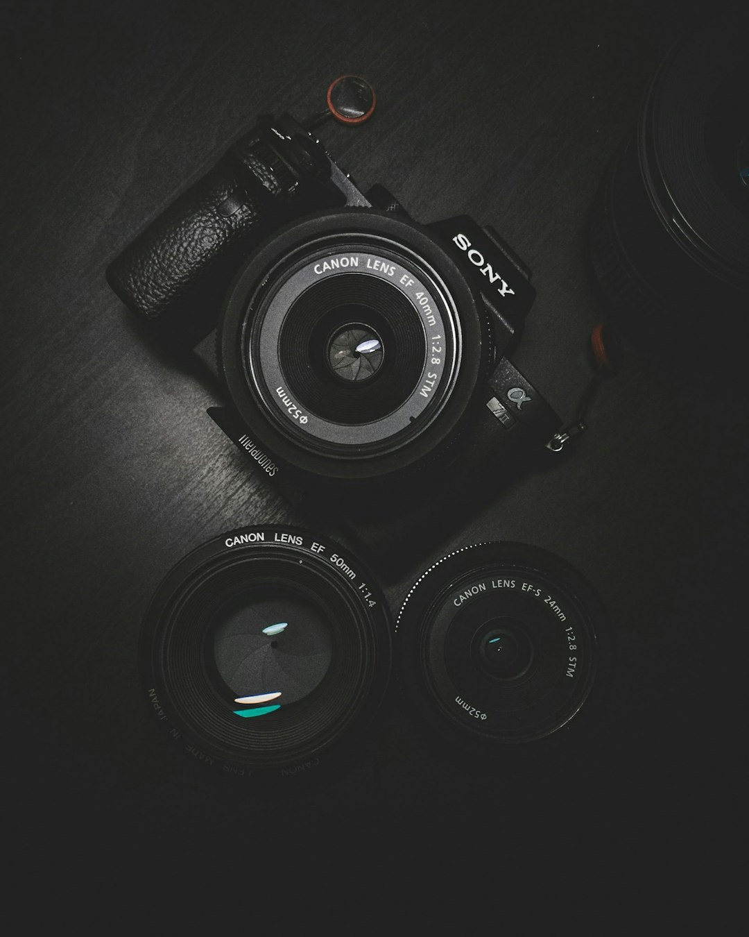 A DSLR camera body laid flat on a dark surface