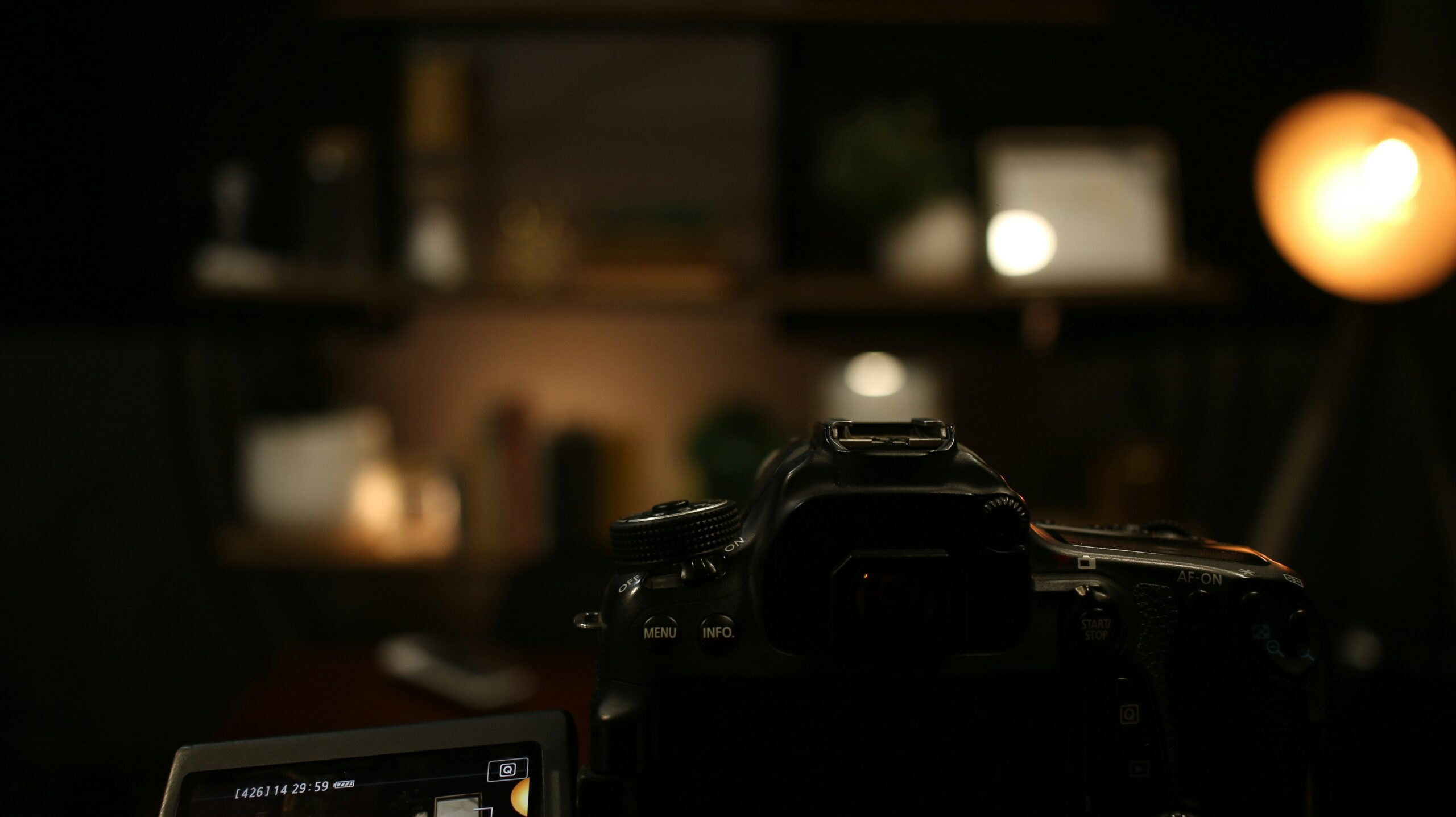 A DSLR camera on a table, ready to have its ISO and exposure settings adjusted