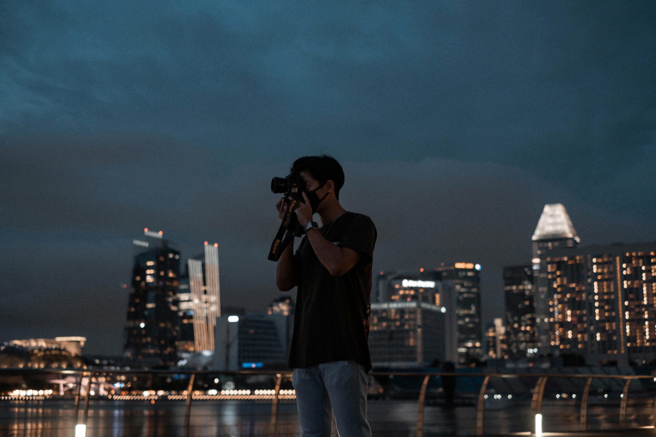 A photographer shooting at night, the kind of low-light situation that tends to push ISO up and introduce noise