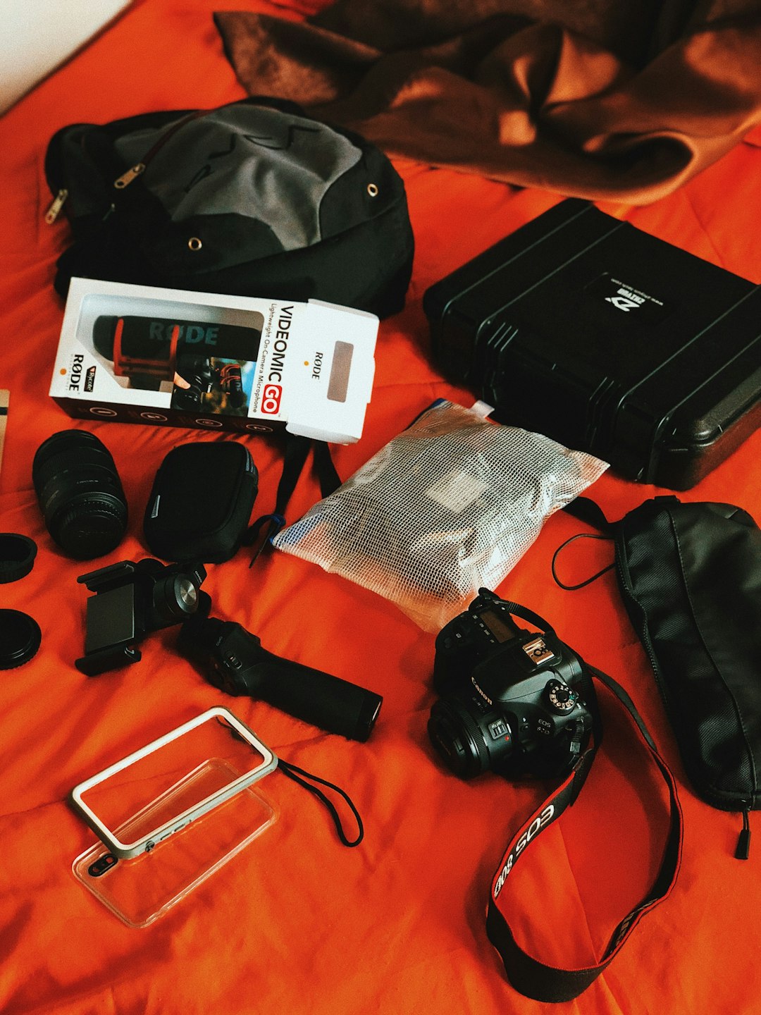 DSLR camera resting beside a travel camera backpack