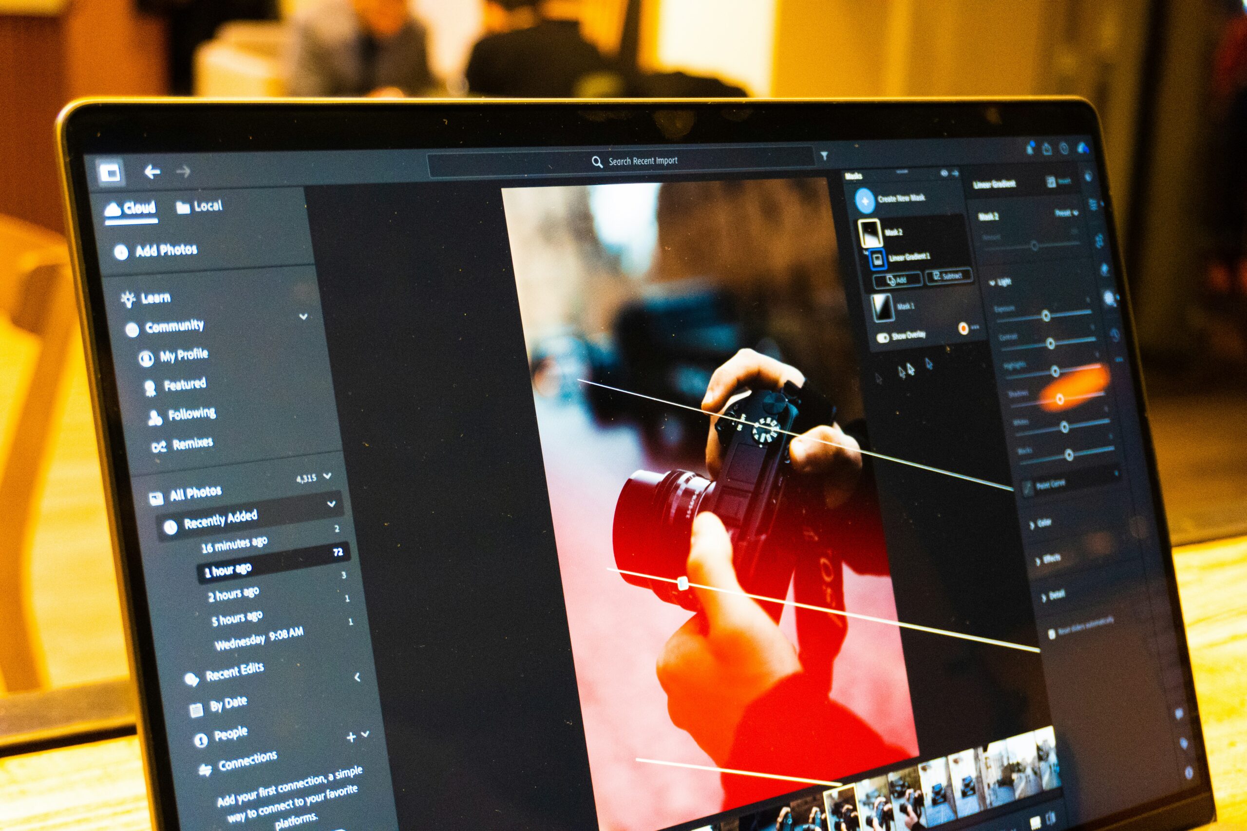 Photo editing software open on a laptop screen, the kind of noise reduction tools used to clean up grainy shots